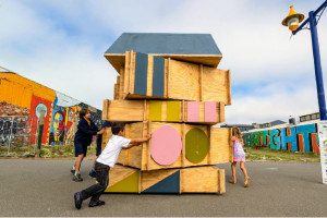 Three children spin the sections of a rotating hut