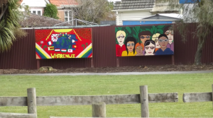 Two murals on sign boards in a grassed area